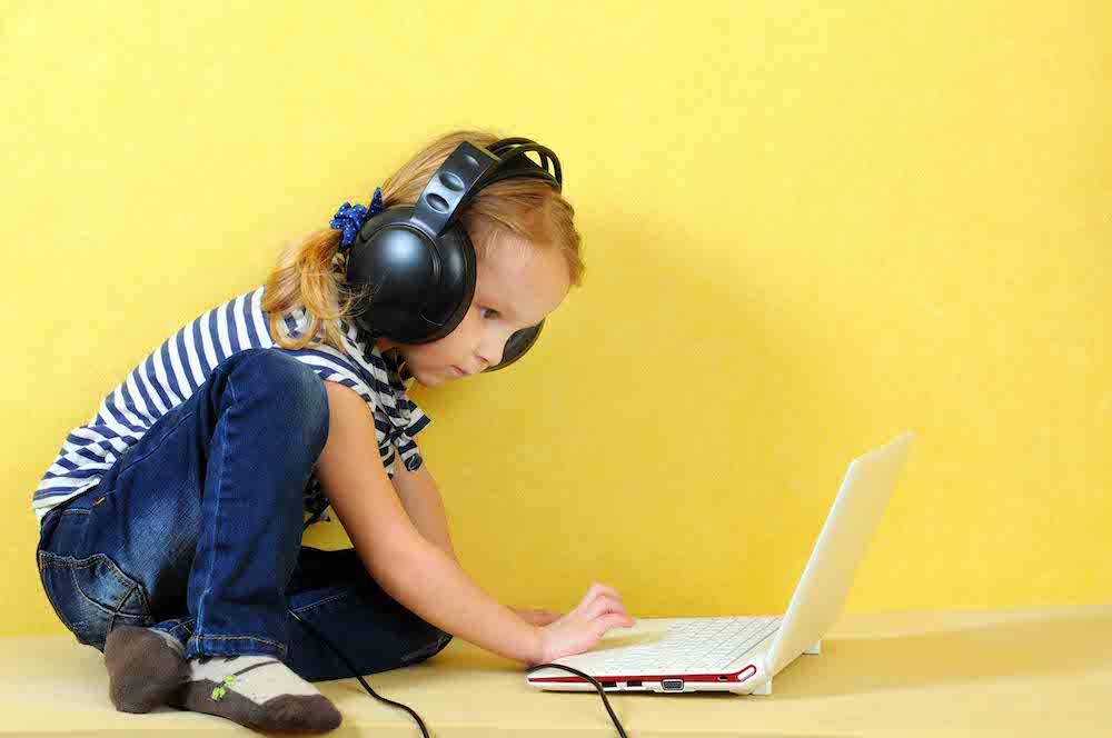 young girl on a laptop with headphones